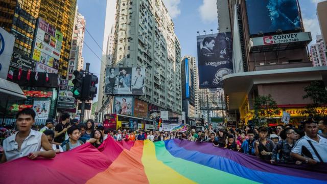 Participants carry a large flag as they take part in a Gay Pride procession in Hong Kong on November 10, 2012. As anti-discrimination laws continues to expand globally, the participant marched to promote equal rights for lesbian, gay, bisexual and transgender (LGBT).