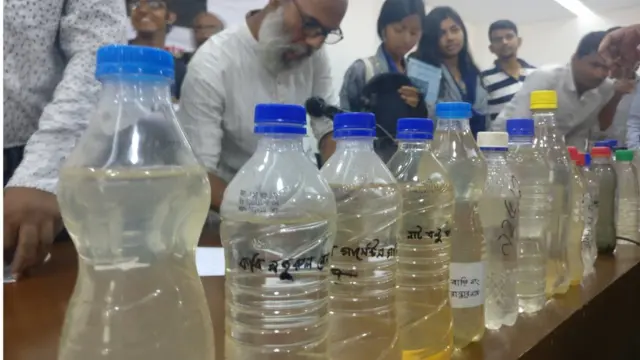 গণশুনানিতে ঢাকার কয়েকটি এলাকার পানি বোতলে ভরে টেবিলের উপর সাজিয়ে রাখা হয়েছিলো।