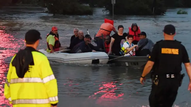 People are rescued from a hotel by boat after Hurricane Harvey caused heavy flooding in Houston, Texas on August 27, 2017.