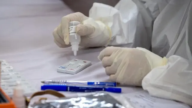 أحد عناصر الفرق الطبية في فيتنام يفحص عينة دم للكشف عما إذا كانت تحتوي على (كوفيد - 19) أم لا