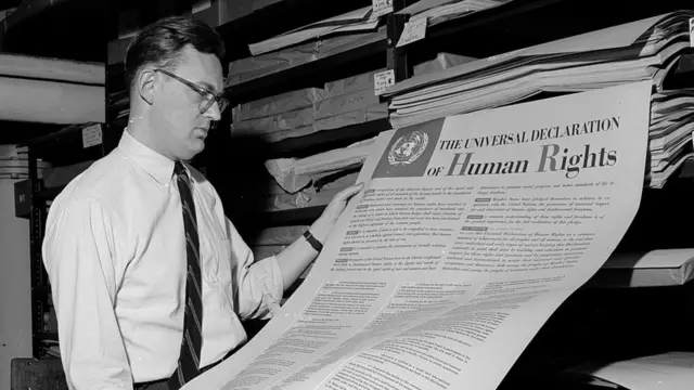 Homem contempla a Declaração Universal dos Direitos Humanos, um dos primeiros documentos publicados pela ONU