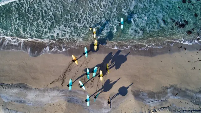 Спортсмены идут с досками к воде