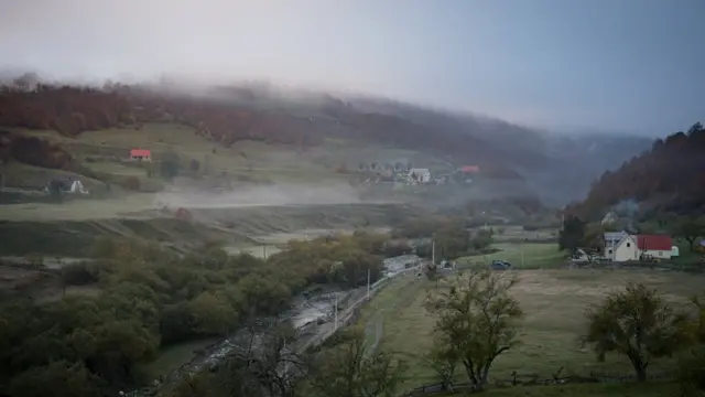 Paisagem do vale com névoa e algumas casas