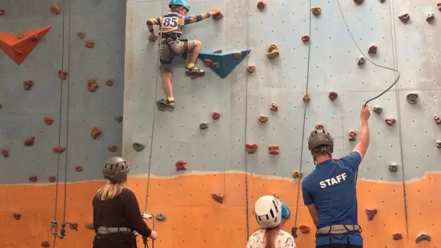 crianças aprendem escalada no centro para refugiados