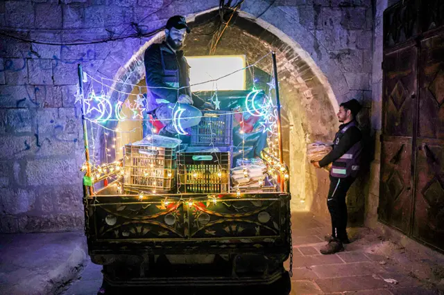 متطوعون خيريون يوزعون رزمًا غذائية لوجبة السحور في إدلب ، شمال غرب سوريا ، في 19 أبريل/نيسان 2022 ، قبيل صيام شهر رمضان.