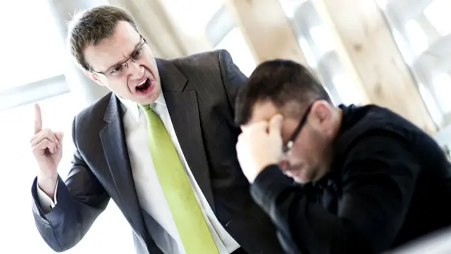 Hombre de negocios de pie regañando a otro.