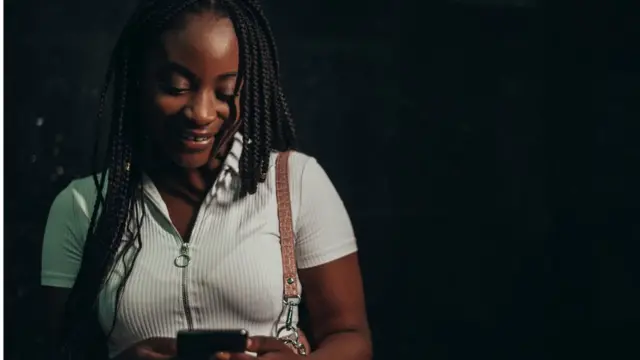 Une jeune femme noire regardant son smartphone