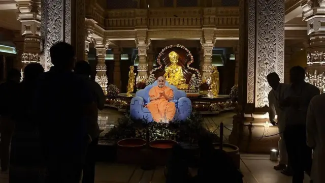 ગાંધીનગરના અક્ષરધામ મંદિરમાં ભગવાન સ્વામીનારાયણ મૂર્તિની પાસે રાખવામાં આવેલું પ્રમુખ સ્વામીનું જીવંત ચિત્ર