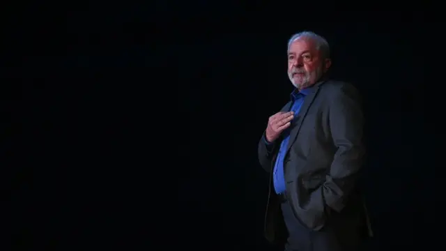 Lula caminhando, em frente a fundo preto