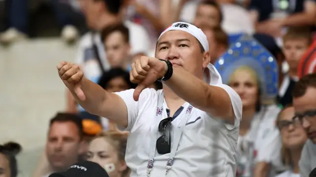 Un aficionado japonés hace una señal con los pulgares hacia abajo durante el partido de Japón y Polonia en Rusia 2018