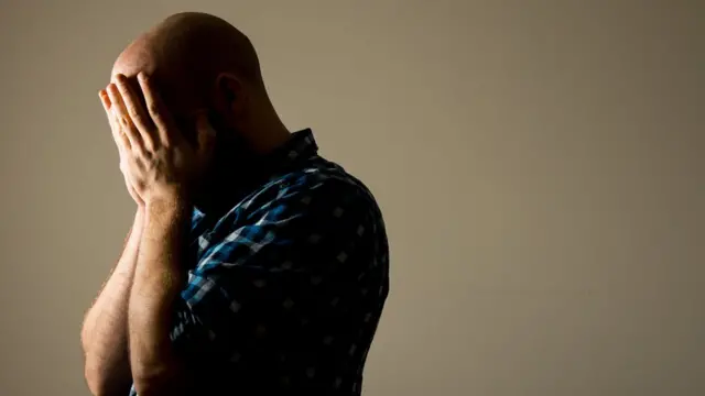 Мужчина закрывает лицо руками