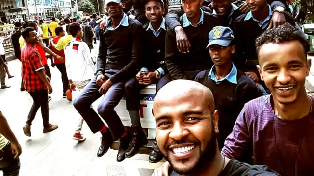 ከፖሊስ አባላት ጋር ፎቶ የሚነሱ ወጣቶች