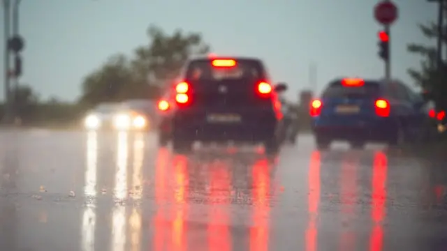 Autos vistos desde atrás, con las luces de frenos encendidas, en un día lluvioso