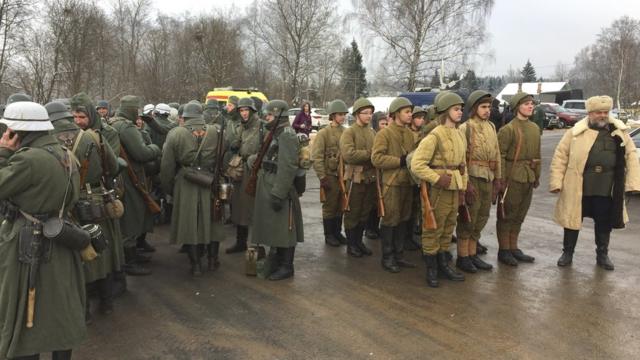 Реконструкторы в форме советских и немецких солдат перед воссозданием боя