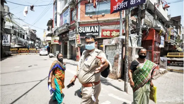 कोरोना के दौरान एक बाज़ार में तैनात पुलिसकर्मी