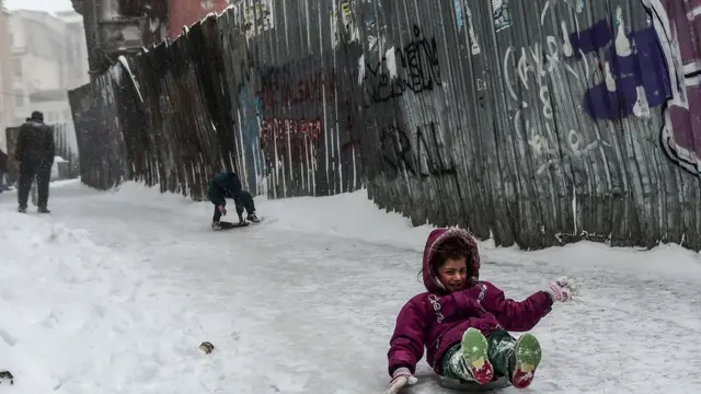 Ребенок катится по заснеженной дорожке в Стамбуле