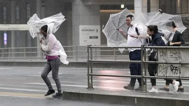 Pedestres têm dificuldade para caminhar por causamelhores slots para ganhar dinheiro betanochuva e vento fortes