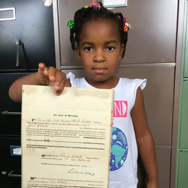 Little girl holding up old record