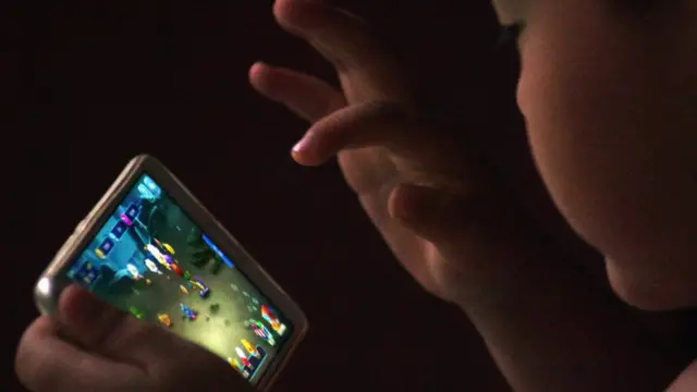 ఫోన్లో కంప్యూటర్ గేమ్ ఆడుతున్న చిన్నారి