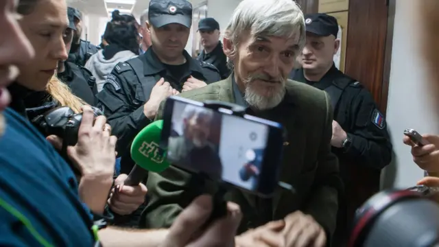 Yuri Dmitriyev, the head of the Karelia Memorial historical society, accused of producing child pornography involving his stepdaughter, paedophilia, and possessing parts of firearms, talks to the media after a hearing at Petrozavodsk City Cour