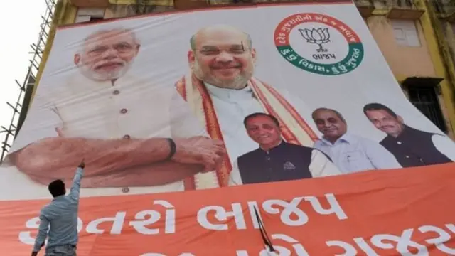 ભાજપના પોસ્ટર સામે ઊભેલો એક વ્યક્તિ