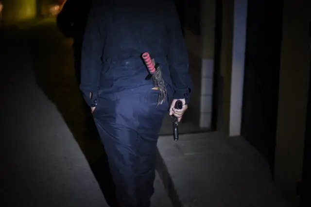 Hombre con pistola de espaldas.