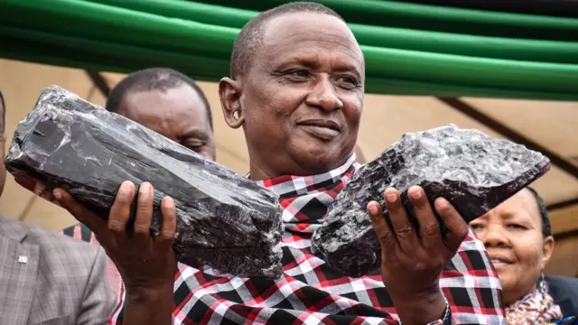 Tanzanian small-scale miner Saniniu Kuryan Laizer poses with two of the biggest of the country's precious gemstones, Tanzanite, as a millionaire during the ceremony for his historical discovery in Manyara, northern Tanzania 24 June, 2020.