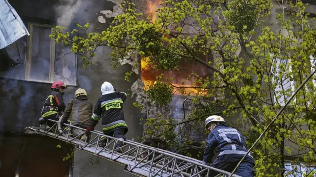 فرق الإطفاء تكافح النيران بعد ضرب صاروخ للمنطقة.