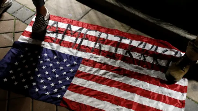 люди наступают на американский флаг