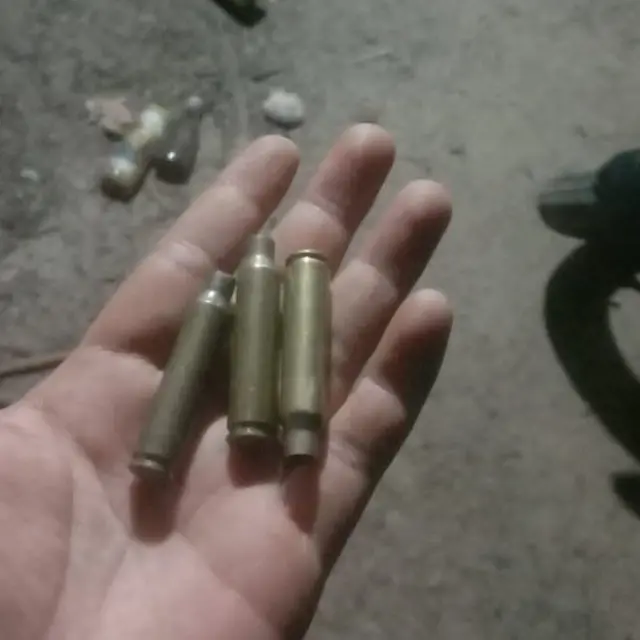 Seorang warga menunjukan selongsong peluru yang ditemukan di lokasi bentrokan.