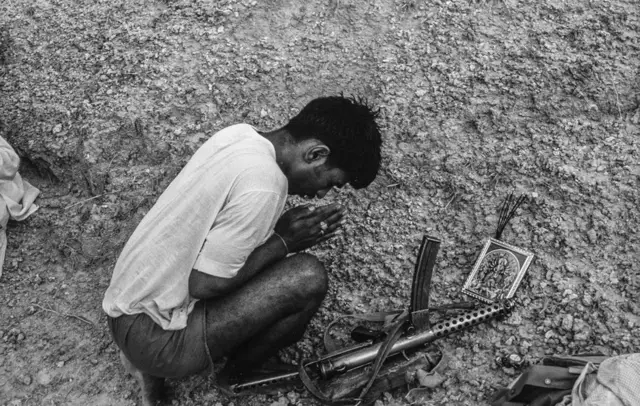 లొంగిపోవడానికి ముందు ఆయుధాన్ని దేవతా చిత్రపటం ముందు ఉంచి మొక్కుతున్న మల్ఖాన్ సింగ్ గ్యాంగ్ సభ్యుడు