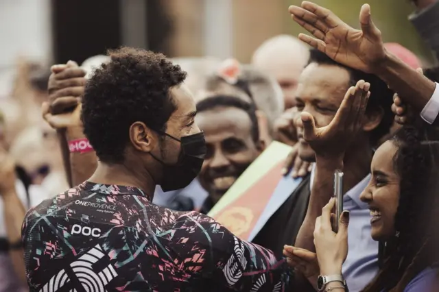 Umunyonzi w'umunye-Eritrea Biniam Girmay wo mw'ikipe Team Wanty yigina hamwe n'abafana biwe imbere y'intango y'ihiganwa Giro d'Italia rigira 105 i Viegrad, Hungary.