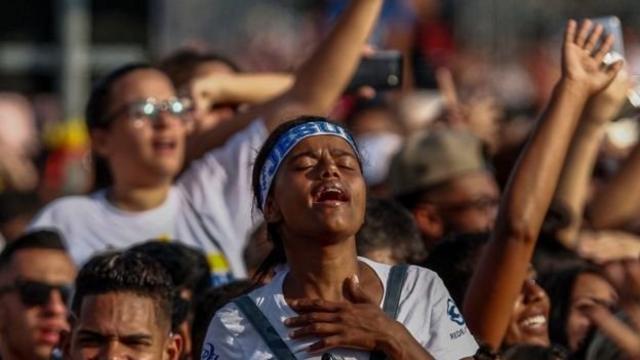 Mulher evangélica ora durante Marcha para Jesus