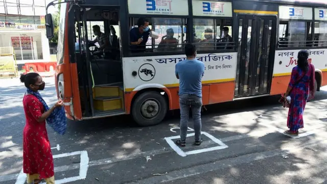 আসামের গুয়াহাটিতে বাসের জন্য সামাজিক দূরত্ব মেনে অপেক্ষা করছেন কয়েকজন যাত্রী - চৌঠা মে ২০২১