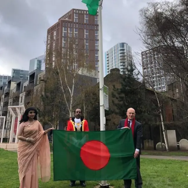 আলতাব আলী পার্কে বাংলাদেশের পতাকা উত্তোলন অনুষ্ঠান। পতাকা ধরে আছেন হাইকমিশনার সাঈদা মুনা তাসনিম এবং মেয়র জন বিগস্‌।