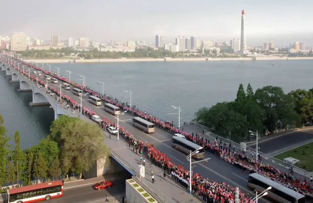 平壤民众在桥上夹道欢迎"火星-12"型地对地中远程战略弹道导弹开发人员乘坐的大巴，朝中社5月19日资料照片。