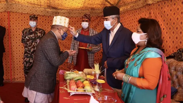 प्रधानमन्त्री निवास बालुवाटारमा टीका लगाइदिँदै प्रधानमन्त्री शेरबहादुर देउवा