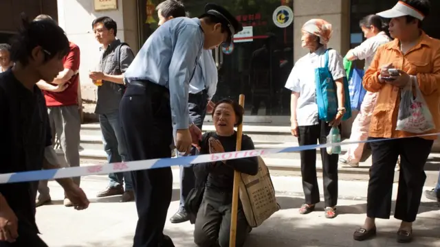Una peticionaria china protestando frente a un policía.
