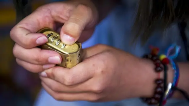 Niño tratando de abrir un candado