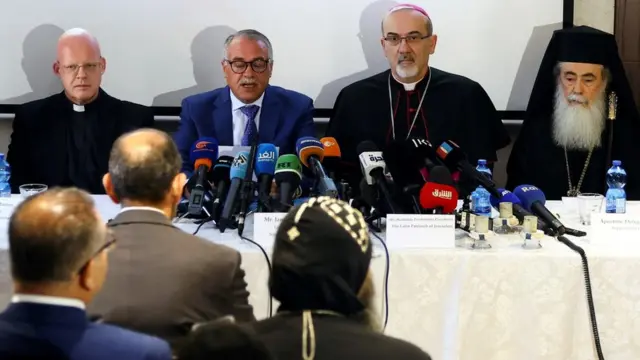 المونسنيور توماش غريسا (إلى اليسار)، ومدير مستشفى القديس يوسف جميل موسى (الثاني من اليسار)، والبطريرك اللاتيني رئيس الأساقفة بييرباتيستا بيتسابالا (الثاني إلى اليمين)، وبطريرك الروم الأرثوذكس ثيوفيلوس الثالث (إلى اليمين) يتحدثون في مؤتمر صحفي في القدس في 16 مايو/أيار 2022