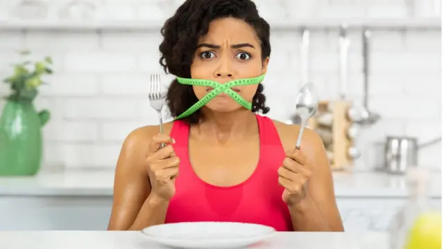 Femme devant une assiette vide