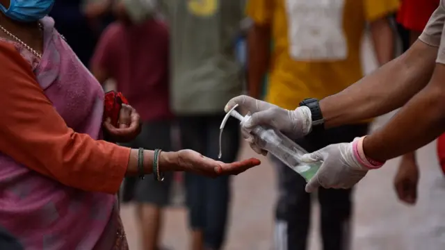 સૅનિટાઇઝર આપતા યુવક