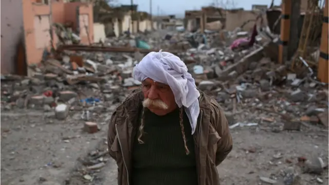 A Yazidi man walks through the rubble of his neighborhood on November 15, 2015 in Sinjar, Iraq.