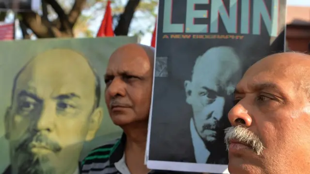 લેનિનના પોસ્ટર સાથે પ્રદર્શન કરતા વ્યક્તિ