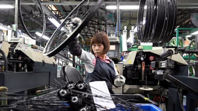 This picture taken on May 21, 2019 shows a worker checking e-bike parts at the factory of Giant -- the world's biggest bicycle manufacturer -- in Taichung