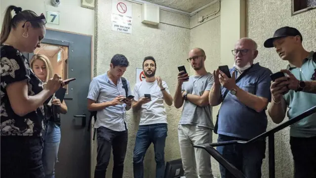 آدم التقط هذه الصورة لزملائه في فصل تعلم العبرية وهم يتابعون مواقع التواصل الاجتماعي لمعرفة الأخبار أثناء اختبائهم في مخبأ الأسبوع الماضي