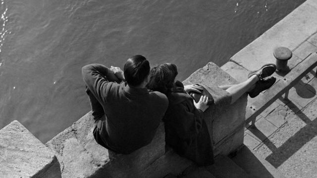 一对年轻伴侣坐在河边