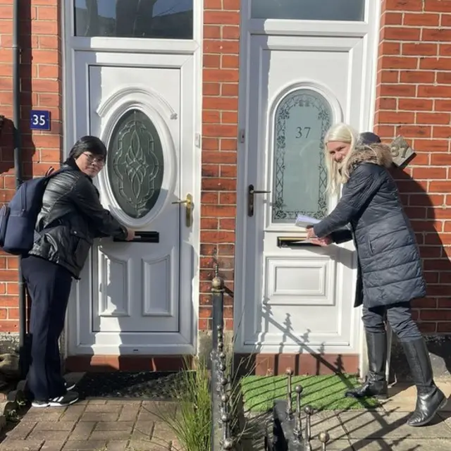 Jihyun Park menaruh pamflet melalui kotak surat bersama dengan rekan kerja.