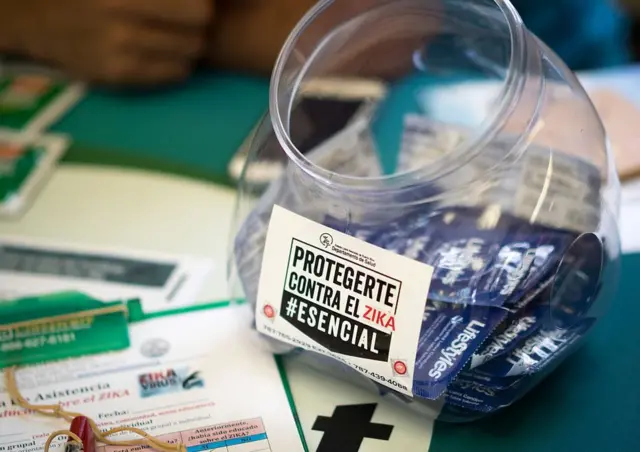 Bote con preservativos con una pegatina que anima a usarlos para protegerse contra el virus del zika.