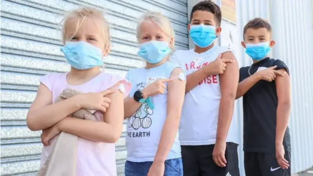 Brothers Louise and Harry Taylor-Bishop and sisters Olivia and Evie Kurz pose for a photo after receiving their first vaccine at Kippa Ring Communication Vaccination Clinic, Brisbane, Australia, 10 January 2022
